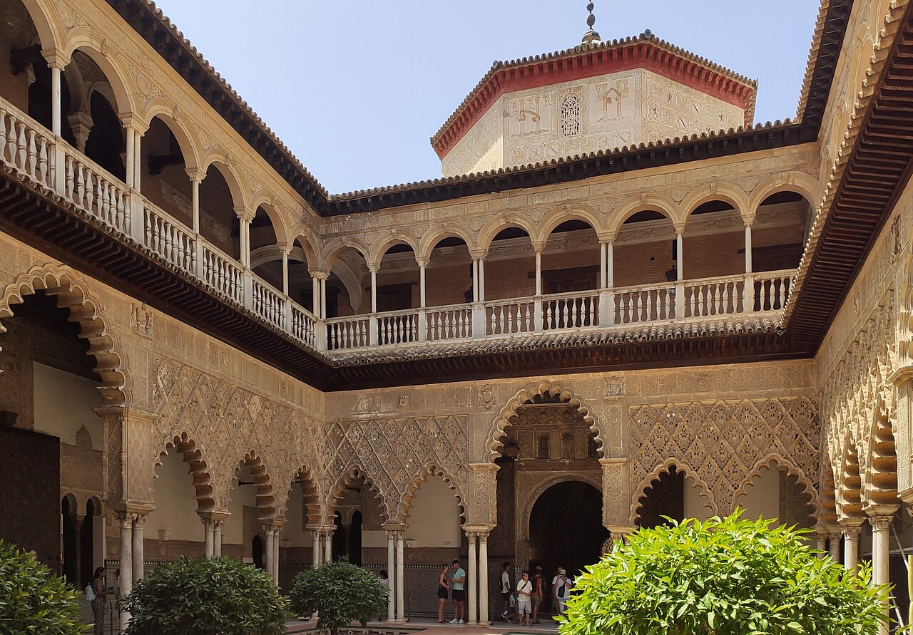 The reflecting pool and arcades of the Patio de las Doncellas at the Real Alcázar, photographed in 2023.